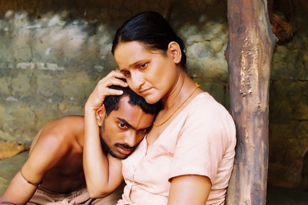 A woman holding a man's head against her shoulder.